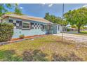 Charming single-story home featuring a colorful facade, brick walkway, and well-maintained landscaping at 3045 Stratford Dr, Largo, FL 33771