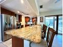 Spacious kitchen features a large granite countertop island, stainless steel appliances, and wood cabinetry at 3240 Sand Key Dr, Palm Harbor, FL 34684