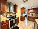 Well-equipped kitchen features tile backsplash, granite counters, stainless steel appliances and wood cabinets at 3240 Sand Key Dr, Palm Harbor, FL 34684