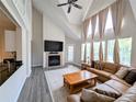 A well-lit living room featuring a vaulted ceiling, fireplace, and modern flooring at 3305 Haviland Ct # 301, Palm Harbor, FL 34684