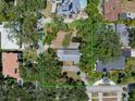 Aerial view of the home with a generous lot size, mature trees, and a pond in the backyard at 4315 W Azeele St, Tampa, FL 33609