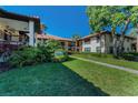 Exterior of building with green grass, walkway, mature plants and trees at 502 Hammock Pine Blvd # 502, Clearwater, FL 33761