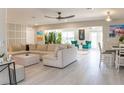 Bright and airy living room with hardwood floors, sectional sofa, and large windows at 600 Eleuthera Dr, Punta Gorda, FL 33950