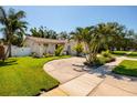 Well-kept single-story home with a circular driveway, tropical landscaping, and white fence at 6001 19Th Ne St, St Petersburg, FL 33703