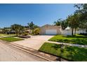 Inviting one-story home featuring a manicured lawn and garden beds with colorful flowers at 6001 19Th Ne St, St Petersburg, FL 33703