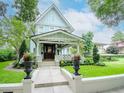 Charming light blue two-story craftsman home with well-maintained lawn, landscaping, and welcoming front porch at 712 S Newport Ave, Tampa, FL 33606