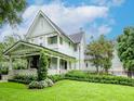 Beautiful two-story light blue craftsman-style house with a covered front porch and lush, green landscaping at 712 S Newport Ave, Tampa, FL 33606