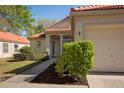 Home featuring a red tile roof, well-maintained landscaping, and an attached two-car garage at 717 Lighthouse Dr, Tarpon Springs, FL 34689