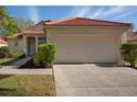 Home featuring a red tile roof, well-maintained landscaping, and an attached two-car garage at 717 Lighthouse Dr, Tarpon Springs, FL 34689