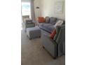 Comfortable living room with plush gray seating, accent pillows, and a cozy atmosphere at 7530 Broad Pointe Dr, Zephyrhills, FL 33540