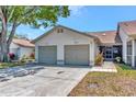 Well-kept home featuring an attached two-car garage, cozy screened porch, and landscaped yard at 8206 Leafy Ct, Port Richey, FL 34668