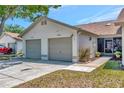 Well-kept home featuring an attached two-car garage, cozy screened porch, and landscaped yard at 8206 Leafy Ct, Port Richey, FL 34668
