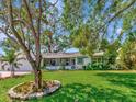 Inviting single-story home with lush green lawn, mature tree, and a quaint screened-in porch at 8326 40Th N Pl, St Petersburg, FL 33709