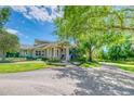 Charming home showcasing lush landscaping, mature trees, and a welcoming stone-accented entryway at 898 Cypress Lakeview Ct, Tarpon Springs, FL 34688