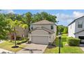 Charming two-story home with a well-manicured lawn and brick-paved driveway at 9908 Spice Bush Ct, Tampa, FL 33647