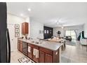 Open-concept kitchen with granite countertops, dark wood cabinetry, and seamlessly connects to the dining and living areas at 10687 Lake Montauk Dr, Riverview, FL 33578