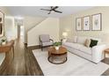 Bright living room showcasing neutral decor, hardwood floors, a ceiling fan, and art at 10807 Keys Gate Dr, Riverview, FL 33579