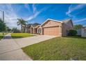 Attractive single-Gathering home with a well-manicured lawn and attached two-car garage on a sunny day at 10841 Standing Stone Dr, Wimauma, FL 33598