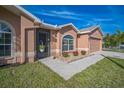 Close up of house entrance highlighting the well-kept landscaping and charming architectural details at 10841 Standing Stone Dr, Wimauma, FL 33598