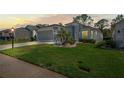 Exterior shot of the home at dusk, showcasing the well-manicured lawn and tasteful landscaping at 11250 Hollander Ave, Hudson, FL 34667