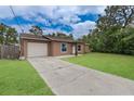 View of single story home with a driveway leading to an attached one car garage at 11396 Terrell Rd, Spring Hill, FL 34608