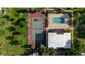 Aerial view of community tennis court and pool surrounded by lush greenery at 14419 Americana Cir # 103, Tampa, FL 33613