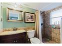 Cozy bathroom featuring a tiled shower and dark wood vanity with decorative mirror at 14419 Americana Cir # 103, Tampa, FL 33613
