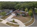 Aerial view of a charming home with a large driveway and mature trees at 1686 Spottswood Cir, Palm Harbor, FL 34683