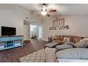Comfortable living room with vaulted ceiling, wood-look flooring, a ceiling fan, and neutral-toned walls at 23253 Granite Pl, Land O Lakes, FL 34639