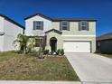 Two-story house with a two-car garage, neutral paint, and minimal landscaping for a clean, modern look at 238 Argyll Dr, Spring Hill, FL 34609