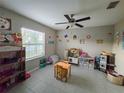 Bright living area with ceiling fan, window, tile flooring, and furniture for activities at 238 Argyll Dr, Spring Hill, FL 34609
