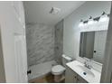 Modern bathroom showcasing a tiled shower, and stylish vanity with ample lighting at 26448 Eager Rd, Punta Gorda, FL 33955