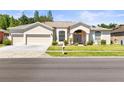 Charming single-story home featuring a well-manicured lawn and a spacious three-car garage at 28451 Great Bend Pl, Wesley Chapel, FL 33543