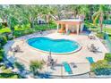 Aerial view of the community pool with ample seating, a covered area and mature shade trees at 2933 Bough Ave # C, Clearwater, FL 33760