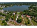 Lakefront home with a pool, grassy yard, and a circular drive, surrounded by mature trees at 3113 W Sligh Ave, Tampa, FL 33614