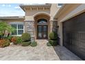 Elegant front entrance featuring stone pillars, a covered entryway, and a beautifully paved driveway at 31382 Chesapeake Bay Dr, Wesley Chapel, FL 33543