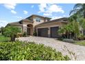 Charming two-story home with stone accents, a paved driveway, two-car garage, and meticulously manicured landscaping at 31382 Chesapeake Bay Dr, Wesley Chapel, FL 33543
