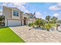 Charming two-story home with paver driveway, lush grass, and a double-car garage at 314 Crosswinds Dr, Palm Harbor, FL 34683