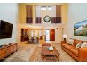 Inviting living room with high ceilings, stylish decor, and seamless flow to the dining area at 34527 Cedarfield Dr, Dade City, FL 33523