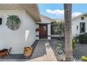 Close-up of a welcoming front entrance with decorative accents and tropical landscaping at 3819 Barnegat Dr, Punta Gorda, FL 33950