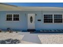 Close-up of the light blue house featuring a white front door and decorative white gravel at 3841 Wahoo Se Dr, St Petersburg, FL 33705