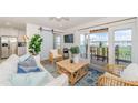 Cozy living room featuring sliding glass doors to deck, modern decor, ceiling fan, and open floor plan at 5094 Starfish Se Dr # E, St Petersburg, FL 33705
