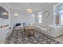 Bright living room featuring a large sectional, decorative rug, and natural light through large windows at 5108 Suncatcher Dr, Wesley Chapel, FL 33545