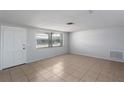 Bright room featuring tile flooring, large window, and a fresh coat of white paint at 5203 Overton Dr, New Port Richey, FL 34652