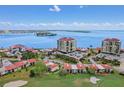 Stunning aerial view of the condo complex with water views, lush landscaping, and golf course at 6322 Palma Del Mar S Blvd # 706, St Petersburg, FL 33715