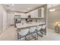 Modern kitchen with white cabinets, stainless steel appliances, a tile backsplash, and a breakfast bar with seating at 6333 Milestone Loop, Palmetto, FL 34221