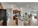 Modern kitchen with granite countertops, an island with seating, and stainless steel appliances at 7236 Salt River Ave, Sun City Center, FL 33573
