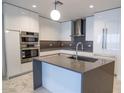 Modern kitchen features sleek white cabinets, stainless steel appliances, and a stylish island with a gray countertop at 777 3Rd N Ave # 1501, St Petersburg, FL 33701