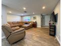 Spacious living room with hardwood flooring, a comfortable leather sectional, and recessed lighting at 8718 Arrowhead Dr, Hudson, FL 34667