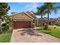 Charming home boasts a brick driveway, well-maintained landscaping, and an attached two-car garage at 11656 Lake Blvd, New Port Richey, FL 34655